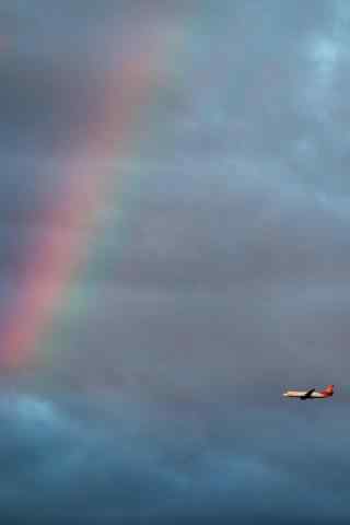 天空中飞过彩虹的飞机手机壁纸