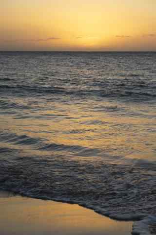 夕阳下的海边沙滩手机壁纸