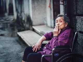 坐在轮椅上抽烟的老奶奶人物摄影图片