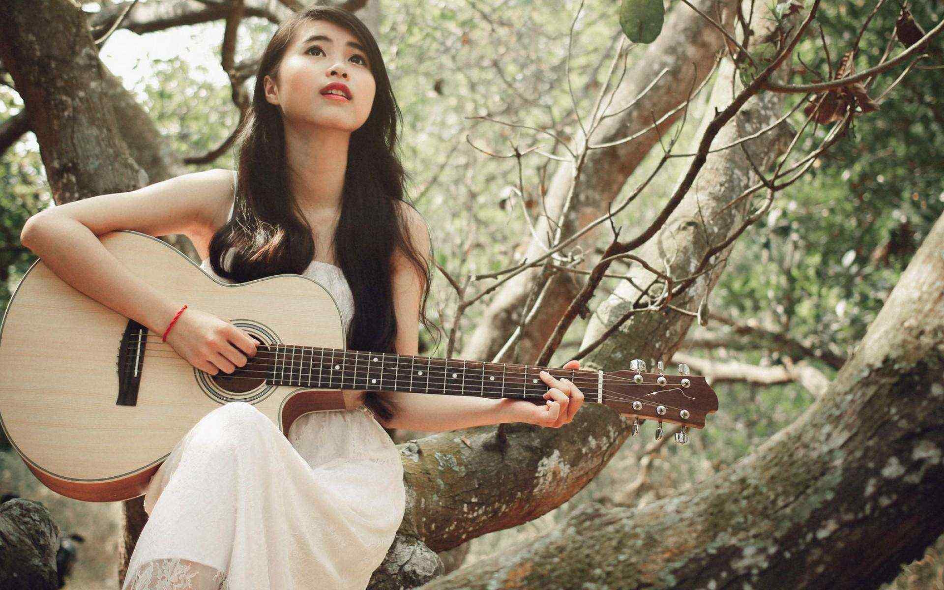 少女在树上弹奏吉他桌面壁纸