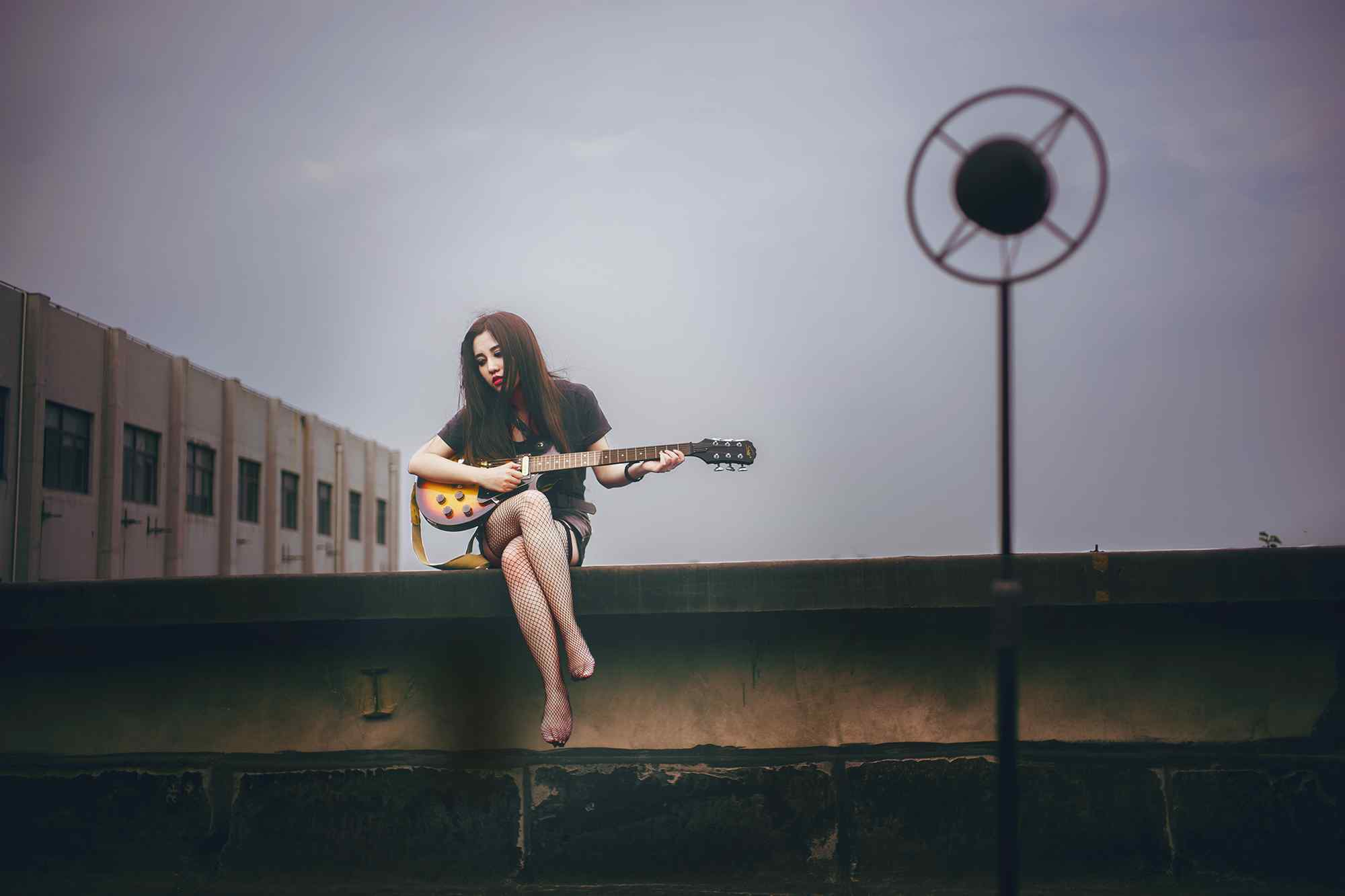 美女在天台上弹奏吉他桌面壁纸