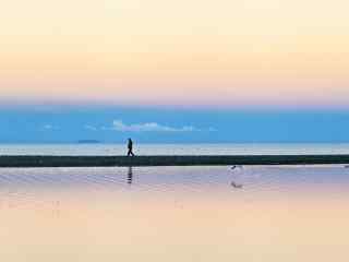 小清新纳木错湖上行走中的孤独游客图片